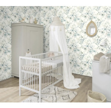 Inredning av ett barnrum med spjälsäng, skötbord, garderob och tapet med bladmotiv