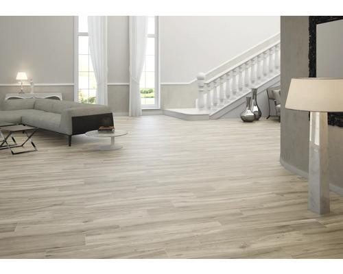 Ljust vardagsrum med soffa, trappa och träimitation klinker