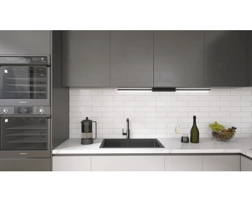 Köksscen med inbyggda Samsung-ugnar, diskho, kran och köksredskap på en bänkskiva