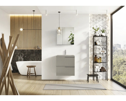 Ljust badrum med tvättställ, spegelskåp, hylla och fristående badkar