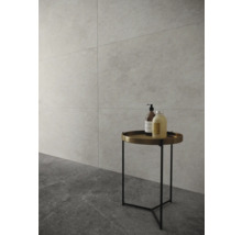 Badrum med klinkergolv och väggplattor, samt ett runt sidobord