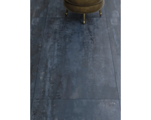 Närbild av golvplattor med industriell design och en pall