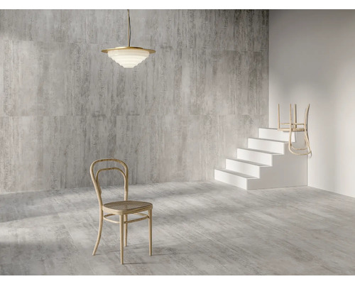 Interiör med gråmönstrade plattor, en taklampa, en stol och en trappa