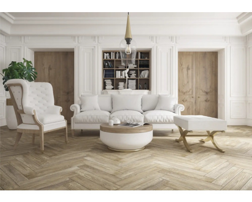 Ljust vardagsrum med soffa, fåtölj och bokhylla