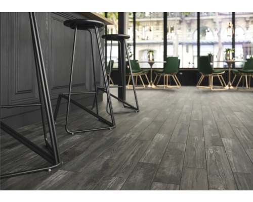 Interiör med grått laminatgolv i trälook och barstolar