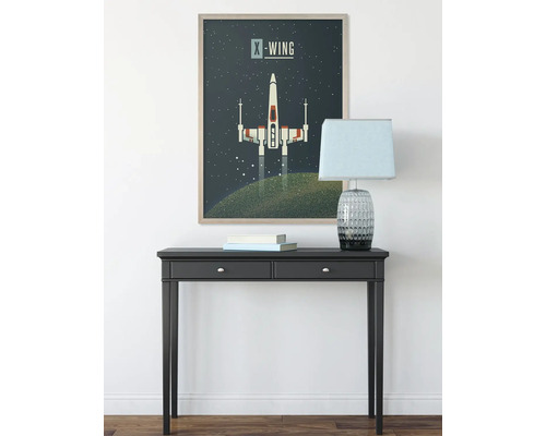 Dekorativ väggbild med X-Wing-motiv över ett svart konsolbord med lampa och böcker
