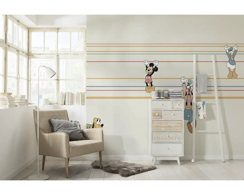 Dekorerat rum med fåtölj, byrå och Disneyfigurer väggdekor