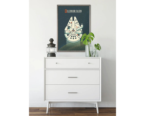 Dekorativ scen med en byrå och en inramad bild av Millennium Falcon