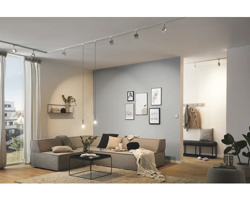 Vardagsrum med belysningssystem i taket, hörnsoffa och dekoration