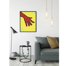 Vardagsrum med soffa, golvlampa, sidobord med växt, hänglampor och inramad bild av en serietidningshand