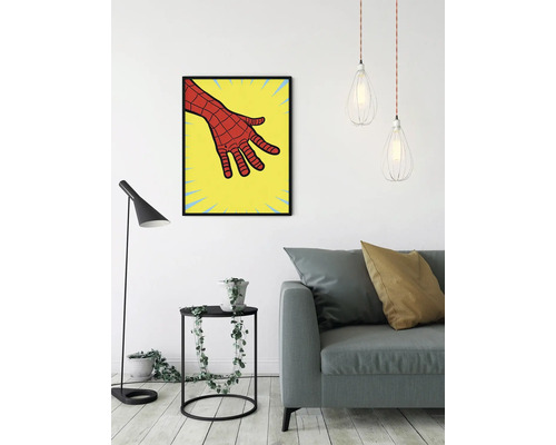 Vardagsrum med soffa, golvlampa, sidobord med växt och en inramad bild av en serietidningshand