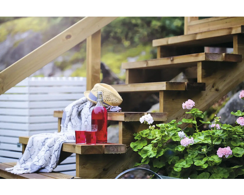 Trätrappa i trädgården med drycker, hatt och dekoration för en avslappnad atmosfär
