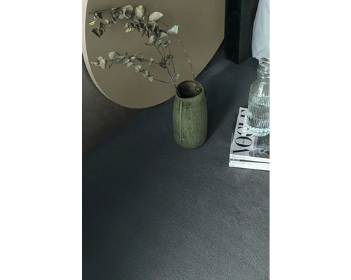 Närbild av ett mörkt golv med vas och dekoration