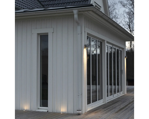 Husfasad med utomhusbelysning och stora fönster