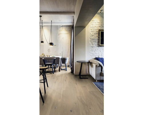 Ljust vardagsrum med trägolv, matbord och soffa