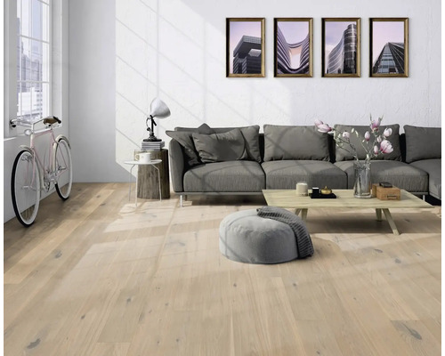 Ljust vardagsrum med trägolv, soffa, bord och cykel.