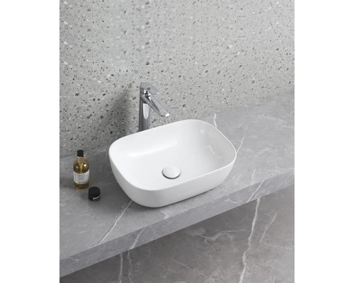 Keramisk handfat på bänkskiva med blandare