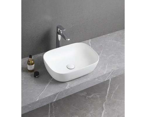 Tvättställ i keramik med blandare på en hylla