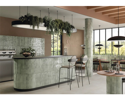 Interiörbild av ett kafé med kakelbeklädnad, sittplatser och belysning