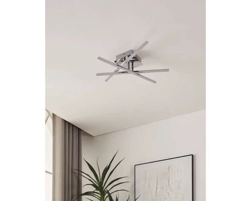 Modern taklampa med flera armar och en fyrkantig bas i ett rumstak.