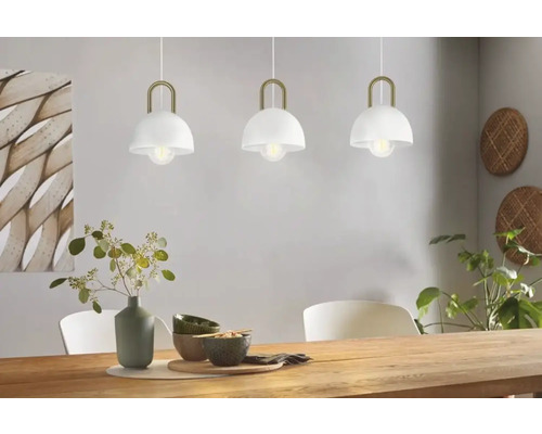 Tre metalliska hänglampor ovanför ett matbord.