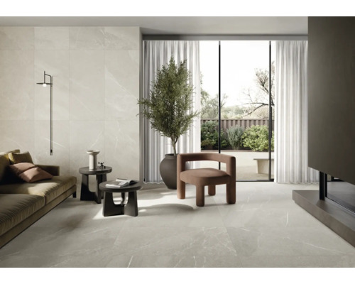 Vardagsrum med klinkergolv och väggplattor i marmorlook, soffa, fåtöljer och krukväxt.