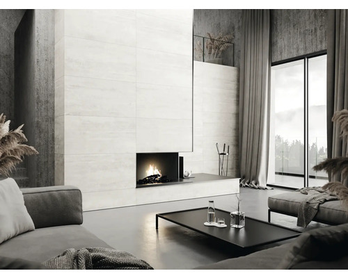 Vardagsrum med öppen spis, kakelvägg, soffa och fönsterfront för en modern boendemiljö.