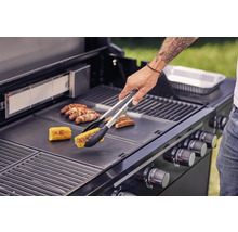 Person grillar majs och korv på en grill.