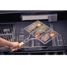 Kött och grönsaker i en grillkorg på en grill