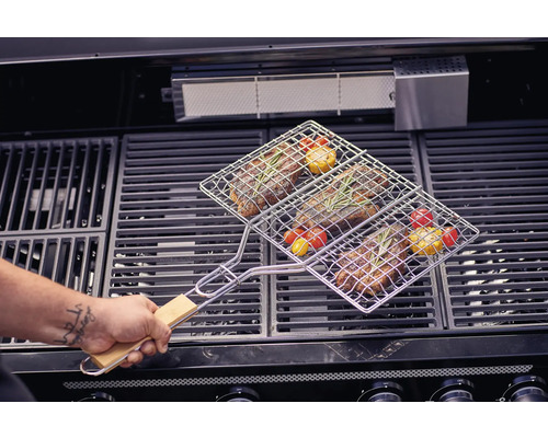 Kött och grönsaker i en grillkorg på en grill