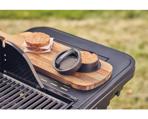 Hamburgarepress med två köttburgare på ett grillbord