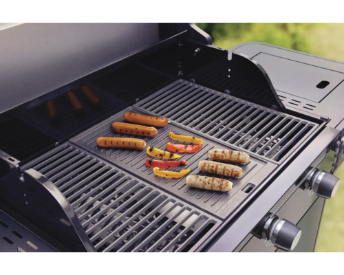 Gasolgrill med korvar och paprika på grillgallret.