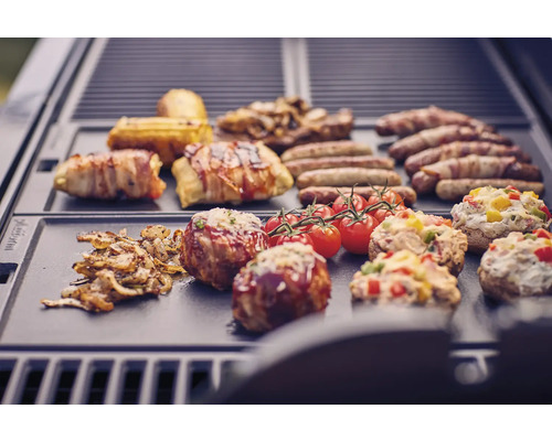 Olika maträtter som korvar, bacon, tomater och fyllda champinjoner på en grill.