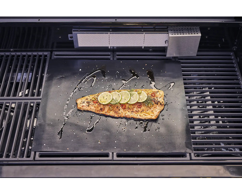 Lax på grillmatta med citronskivor och kryddor i grillen.