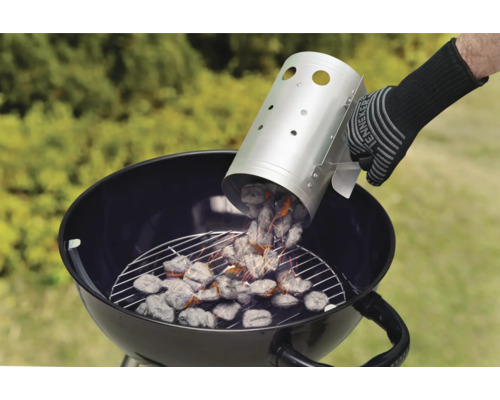 Person häller kol från en skorstenständare i en klotgrill.