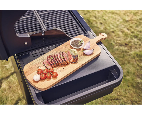 Grill med träskiva, grillat kött, tomater, vitlök, lök och kryddor