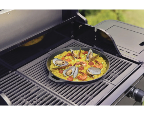Paella med skaldjur tillagad på en grill.