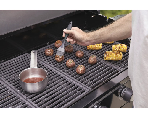 Köttbullar och majskolvar tillagas på en grill.