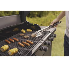 Grill med grillade korvar, hamburgare och majskolvar, som hanteras med grillverktyg