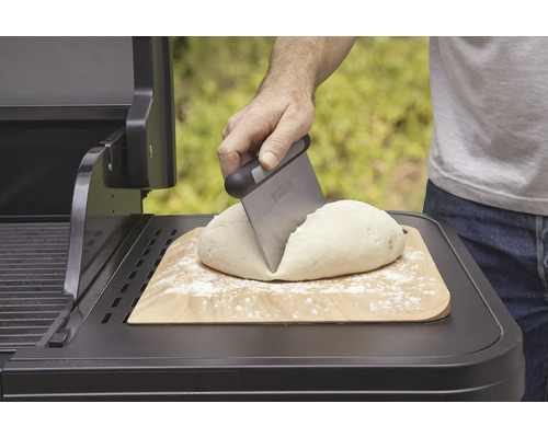 Deg på träbräda delas med degskrapa på grill