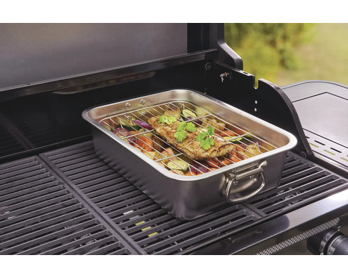 Rostfri stekpanna med fisk och grönsaker på en grill