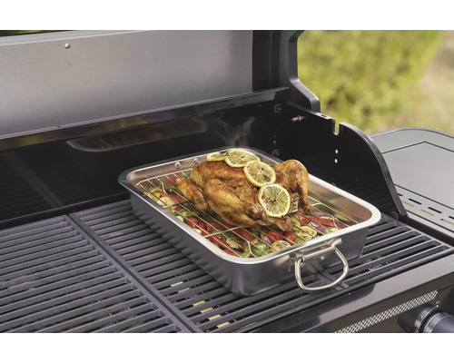 Grillad kyckling med grönsaker i en rostfri behållare på en grill.