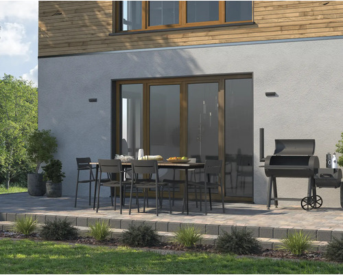 Utomhusmiljö med terrass, trädgårdsbord, stolar och grill för avkopplande stunder utomhus.