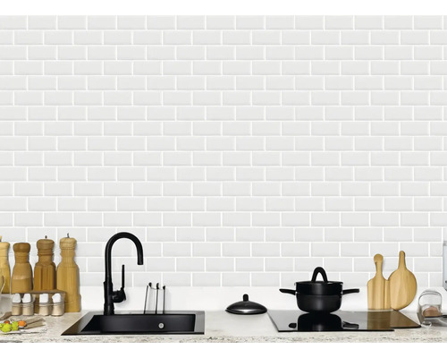 Ljust kök med diskho, spishäll, köksredskap och vita metrokakel