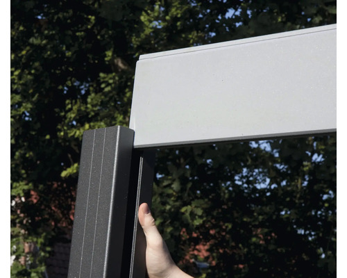 Detaljvy av ett altantak med aluminiumram och en person som rör ramen.