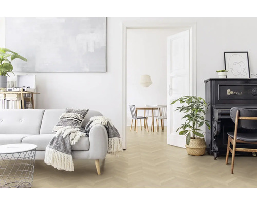 Ljust vardagsrum med soffa, piano och fiskbensparkett