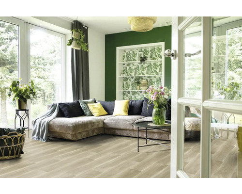 Ljust vardagsrum med soffa, krukväxter och trägolv