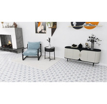 Ljust vardagsrum med fåtölj, byrå och öppen spis