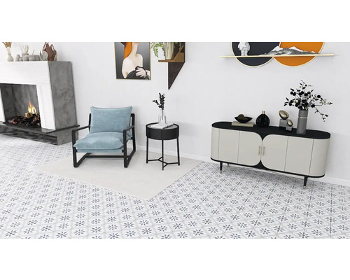 Ljust vardagsrum med fåtölj, byrå och öppen spis