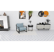 Vardagsrum med öppen spis, fåtölj, sidobord och byrå